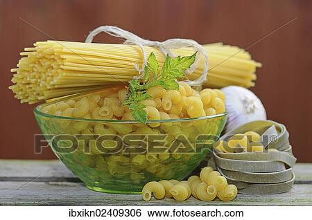 Stock Photograph - Various types of pasta with a glass bowl. Fotosearch