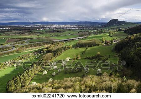 "View from Hohenkraehen Mountain over the spring-like Hegau landscape, Hohentwiel Mountain on the horizon and the town of Singen, Baden-Wuerttemberg, Germany, Europe" View Large Photo Image Stock Image - "View from Hohenkraehen Mountain over the spring-like Hegau landscape, Hohentwiel Mountain on the horizon and the town of Singen, Baden-Wuerttemberg, Germany, Europe". Fotosearch