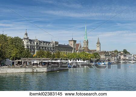Stock Photography - "View from Quaibruecke bridge over the Limmat river, beer garden on the island auf Bauschaenzli, Stadthausquai and the Metropol Building, Fraumuenster Church and the spire of St. Peter church at back, Zurich, Canton of Zurich, Switzerland, Europe". Fotosearch