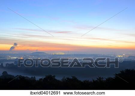 Stock Image - "View from the Halde Norddeutschland spoil tip onto the Lower Rhine and the western Ruhr district at dawn, Neukirchen, North Rhine-Westphalia, Germany, Europe". Fotosearch