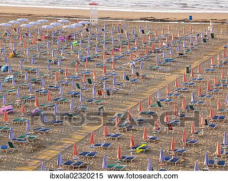 Stock Photography - "View of the beach in the early morning with closed parasols and sun loungers, Lignano Sabbiadoro, Udine, Adriatic Coast, Italy, Europe". Fotosearch