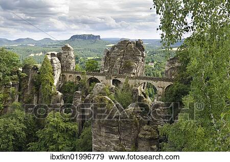 "View of the rocks of the Bastei and the Basteibruecke bridge, behind Mt. Lilienstein, Elbe Sandstone Mountains, Saxony, Germany, Europe" View Large Photo Image Stock Photo - "View of the rocks of the Bastei and the Basteibruecke bridge, behind Mt. Lilienstein, Elbe Sandstone Mountains, Saxony, Germany, Europe". Fotosearch