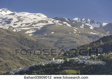 Stock Image - "View over the town of Pampaneira towards the snow-capped Sierra Nevada Mountains, Pampaneira, Andalucia, Spain, Europe". Fotosearch