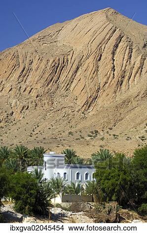 "Villa in an oasis at the foot of a barren mountain at Birkat al Mawz, Sultanate of Oman, Middle East" View Large Photo Image Picture - "Villa in an oasis at the foot of a barren mountain at Birkat al Mawz, Sultanate of Oman, Middle East". Fotosearch