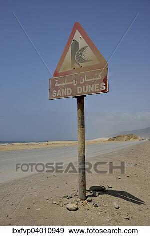 "Warning sign warns of sand dunes, near Mirbat, Dhofar Region, Oman, Asia" View Large Photo Image Stock Photo - "Warning sign warns of sand dunes, near Mirbat, Dhofar Region, Oman, Asia". Fotosearch