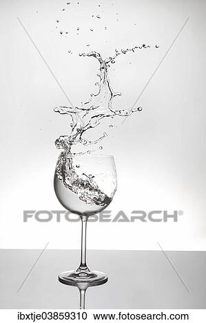 Stock Image - Water splashing out of a wine glass. Fotosearch