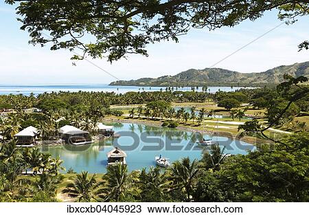 Stock Image - "Waterfront bungalows, South Seas, Plantation Island or Malolo Lailai, Mamanuca Islands, Fiji, Oceania". Fotosearch