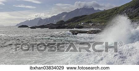"Waves breaking on the rocky coast, cottages and rugged mountains at the back, Flakstad, Lofoten, Nordland, Norway, Europe" View Large Photo Image Stock Photo - "Waves breaking on the rocky coast, cottages and rugged mountains at the back, Flakstad, Lofoten, Nordland, Norway, Europe". Fotosearch