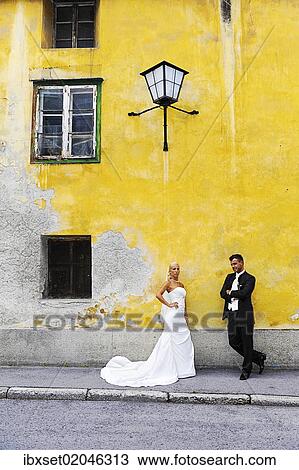 "Wedding, bride and groom in front of a yellow wall" View Large Photo Image Stock Image - "Wedding, bride and groom in front of a yellow wall". Fotosearch