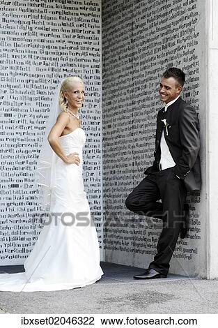 "Wedding, bride and groom standing in front of a wall with letters" View Large Photo Image Stock Image - "Wedding, bride and groom standing in front of a wall with letters". Fotosearch