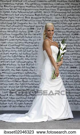 "Wedding, bride with bridal bouquet standing in front of a wall with letters" View Large Photo Image Stock Image - "Wedding, bride with bridal bouquet standing in front of a wall with letters". Fotosearch