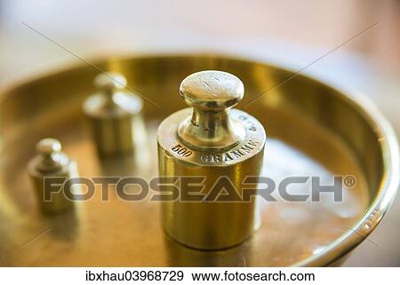 Weights on a golden weighing scale View Large Photo Image Stock Photo - Weights on a golden weighing scale. Fotosearch