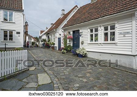 Stock Image - "White wooden houses with floral decorations, historic lane with cobblestones in the historic town centre, Ovre Strandgate, Altstadt, Stavanger, Rogaland, Western Norway, Norway, Europe". Fotosearch