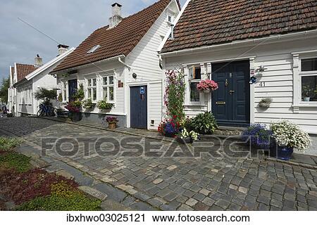 Stock Image - "White wooden houses with floral decorations, historic lane with cobblestones in the historic town centre, Ovre Strandgate, Altstadt, Stavanger, Rogaland, Western Norway, Norway, Europe". Fotosearch