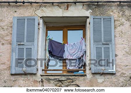 Stock Photo - "Window in a dilapidated building with laundry and open shutters, Corte, Corsica, France, Europe". Fotosearch