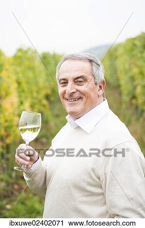 "Winemaker or vintner holding a glass of wine in his vineyard, Rhineland-Palatinate, Germany, Europe" View Large Photo Image Stock Image - "Winemaker or vintner holding a glass of wine in his vineyard, Rhineland-Palatinate, Germany, Europe". Fotosearch