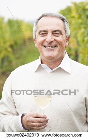 "Winemaker or vintner holding a glass of wine in his vineyard, Rhineland-Palatinate, Germany, Europe" View Large Photo Image Stock Photo - "Winemaker or vintner holding a glass of wine in his vineyard, Rhineland-Palatinate, Germany, Europe". Fotosearch
