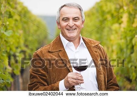 "Winemaker or vintner standing with a glass of red wine in his vineyard, Rhineland-Palatinate, Germany, Europe" View Large Photo Image Picture - "Winemaker or vintner standing with a glass of red wine in his vineyard, Rhineland-Palatinate, Germany, Europe". Fotosearch