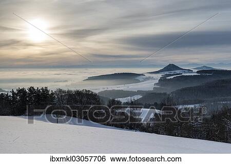 "Winter in Hegau with the volcanic cones of Hohenhewen, left, and Hohenstoffeln, right, with the Swiss Alps on the horizon, Hegaublick, Hegau, Baden-Wurttemberg, Germany, Europe" View Large Photo Image Stock Photograph - "Winter in Hegau with the volcanic cones of Hohenhewen, left, and Hohenstoffeln, right, with the Swiss Alps on the horizon, Hegaublick, Hegau, Baden-Wurttemberg, Germany, Europe". Fotosearch