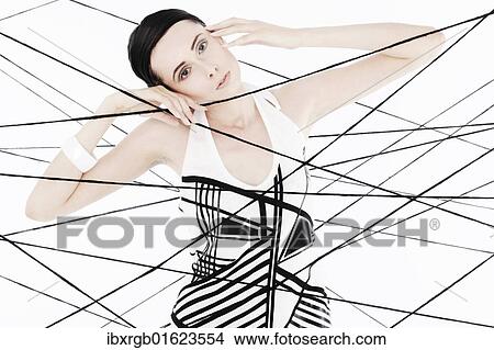 "Woman, 24, dressed in the style of the 60s, standing between spanned threads, symbolic image network" View Large Photo Image Picture - "Woman, 24, dressed in the style of the 60s, standing between spanned threads, symbolic image network". Fotosearch