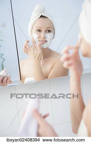 "Woman, 30+, in the bathroom applying a facial mask" View Large Photo Image Picture - "Woman, 30+, in the bathroom applying a facial mask". Fotosearch