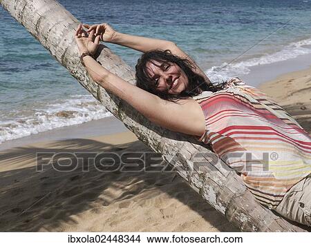 "Woman, 45, relaxing by lying on a palm tree, Punta Uva, Puerto Viejo de Talamanca, Costa Rica, Central America, North America" View Large Photo Image Picture - "Woman, 45, relaxing by lying on a palm tree, Punta Uva, Puerto Viejo de Talamanca, Costa Rica, Central America, North America". Fotosearch