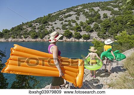 "Woman and children on their way to the beach in a bay, near Donja Klada, Kvarner Gulf, Croatia, Europe" View Large Photo Image Stock Photo - "Woman and children on their way to the beach in a bay, near Donja Klada, Kvarner Gulf, Croatia, Europe". Fotosearch