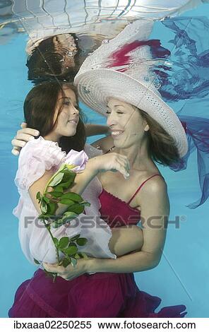 Woman and girl presenting underwater fashion in pool View Large Photo Image Stock Photography - Woman and girl presenting underwater fashion in pool. Fotosearch