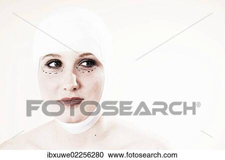 Stock Image - Woman before undergoing plastic surgery with markings on her face. Fotosearch