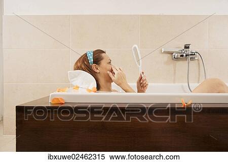 Woman checking her expression lines while bathing View Large Photo Image Stock Photography - Woman checking her expression lines while bathing. Fotosearch