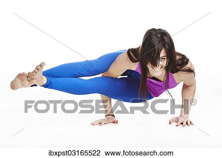 Stock Image - "Woman doing yoga exercises, Astavakrasana". Fotosearch
