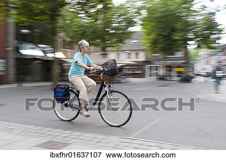 "Woman driving her bike across the marketplace, Grevenbroich, North Rhine-Westphalia, Germany, Europe" View Large Photo Image Stock Photo - "Woman driving her bike across the marketplace, Grevenbroich, North Rhine-Westphalia, Germany, Europe". Fotosearch