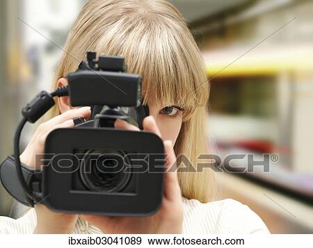 Woman filming with a video camera View Large Photo Image Stock Photo - Woman filming with a video camera. Fotosearch