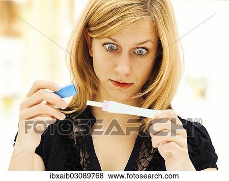 "Woman holding a pregnancy test, looking tense, concentrating and shocked" View Large Photo Image Stock Photo - "Woman holding a pregnancy test, looking tense, concentrating and shocked". Fotosearch