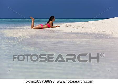 Stock Photo - "Woman in a pink bikini lying on the beach, Male, North Male Atoll, Maldives, Asia". Fotosearch