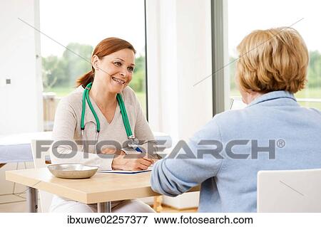 Woman in consultation with her doctor in a practice View Large Photo Image Stock Photo - Woman in consultation with her doctor in a practice. Fotosearch