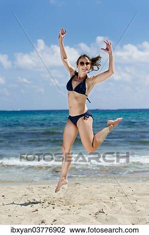 "Woman jumping on the beach, Ibiza, Spain, Europe" View Large Photo Image Stock Image - "Woman jumping on the beach, Ibiza, Spain, Europe". Fotosearch