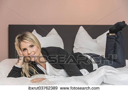 Stock Photo - Woman lying on a bed. Fotosearch