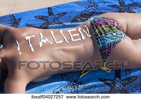 "Woman lying on the beach, writing """"Italy"""" in sun cream on her back, Adriatic, Italy, Europe" View Large Photo Image Stock Photo - "Woman lying on the beach, writing """"Italy"""" in sun cream on her back, Adriatic, Italy, Europe". Fotosearch