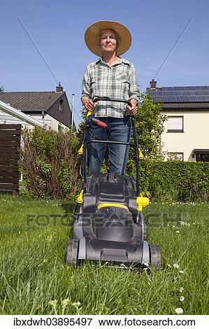 Woman mowing the lawn View Large Photo Image Stock Photo - Woman mowing the lawn. Fotosearch