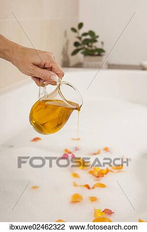 Woman pouring bath oil in a bathtub View Large Photo Image Stock Image - Woman pouring bath oil in a bathtub. Fotosearch