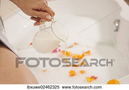 Woman pouring milk into a bath View Large Photo Image Stock Photography - Woman pouring milk into a bath. Fotosearch