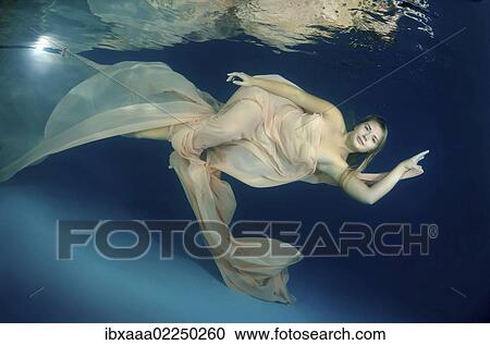 Woman presenting underwater fashion in a pool View Large Photo Image Stock Image - Woman presenting underwater fashion in a pool. Fotosearch