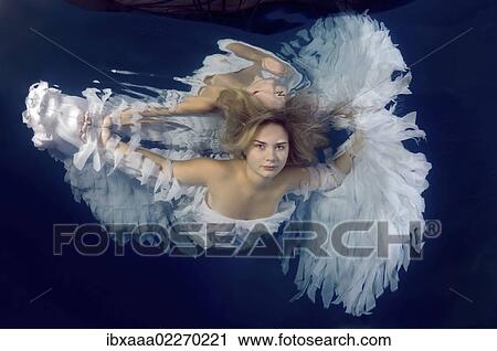 Woman presenting underwater fashion in a pool View Large Photo Image Stock Image - Woman presenting underwater fashion in a pool. Fotosearch
