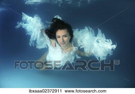 Woman presenting underwater fashion in a pool View Large Photo Image Stock Image - Woman presenting underwater fashion in a pool. Fotosearch