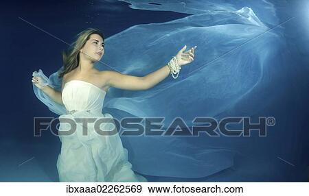 Woman presenting underwater fashion in a pool View Large Photo Image Stock Photo - Woman presenting underwater fashion in a pool. Fotosearch