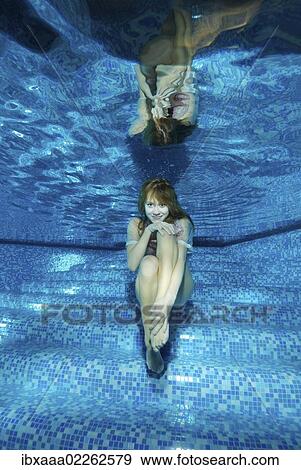 Woman presenting underwater fashion in a pool View Large Photo Image Stock Photo - Woman presenting underwater fashion in a pool. Fotosearch