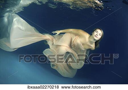 Woman presenting underwater fashion in a pool View Large Photo Image Stock Photo - Woman presenting underwater fashion in a pool. Fotosearch