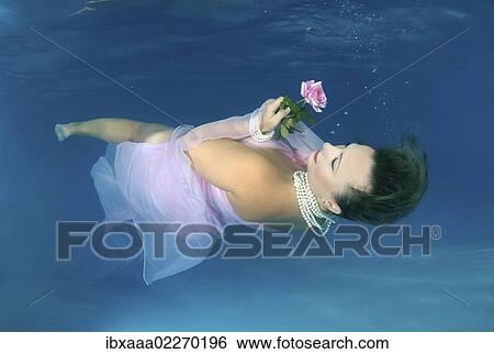 Woman presenting underwater fashion in pool View Large Photo Image Stock Photograph - Woman presenting underwater fashion in pool. Fotosearch