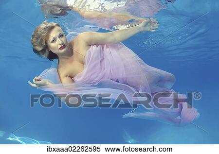 Woman presenting underwater fashion in a pool View Large Photo Image Stock Photography - Woman presenting underwater fashion in a pool. Fotosearch